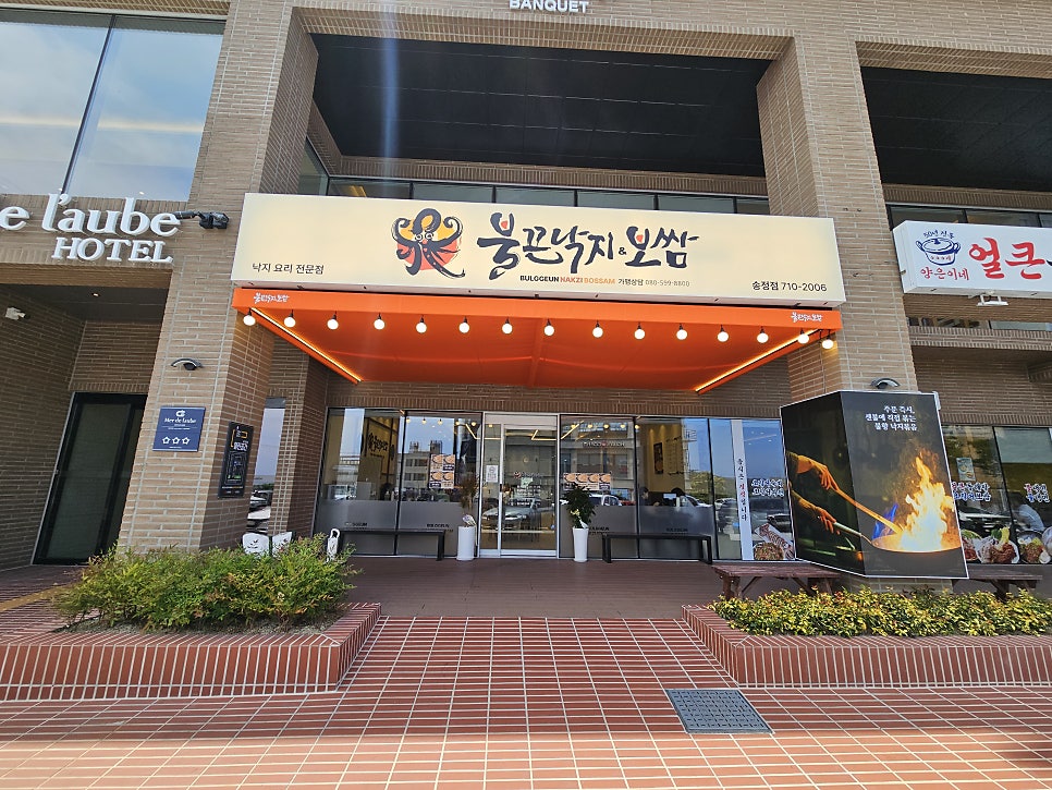 낙지 요리 전문점 간판과 오렌지색 어닝이 걸린 매장 정면
