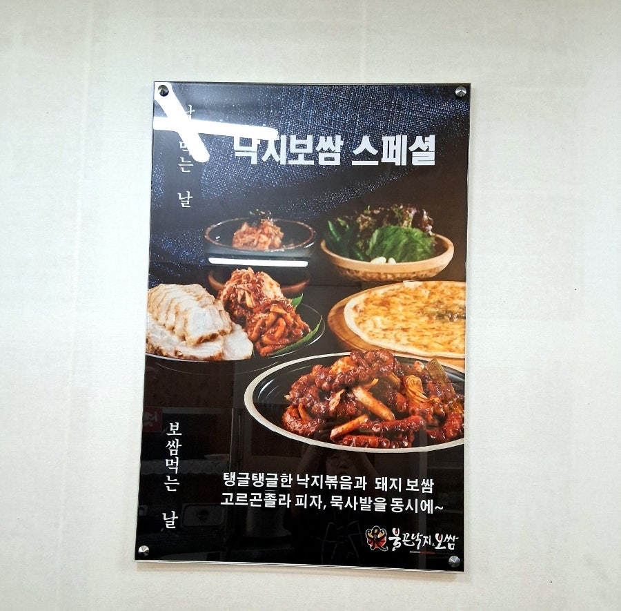 낙지볶음과 보쌈, 고르곤졸라피자, 묵사발 구성을 보여주는 낙지보쌈 스페셜 안내판