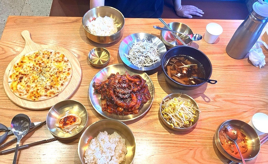 고르곤졸라 피자, 불향 나는 낙지볶음, 시원한 묵사발과 콩나물이 한 상에 차려진 모습