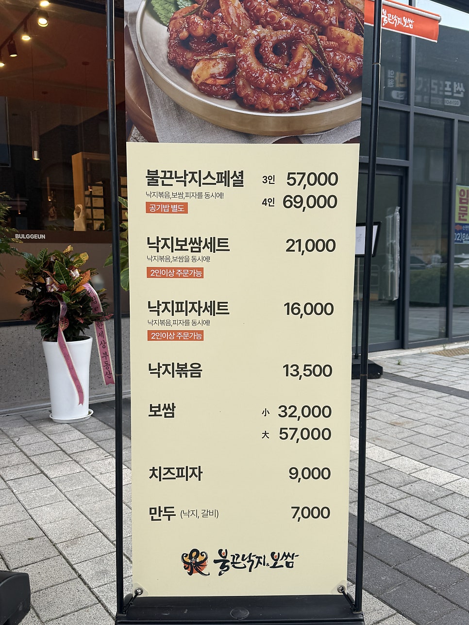 입구에 세워진 메뉴 안내판 — 불끈낙지스페셜, 낙지보쌈세트, 낙지피자세트 등 가격이 한눈에 정리되어 있다