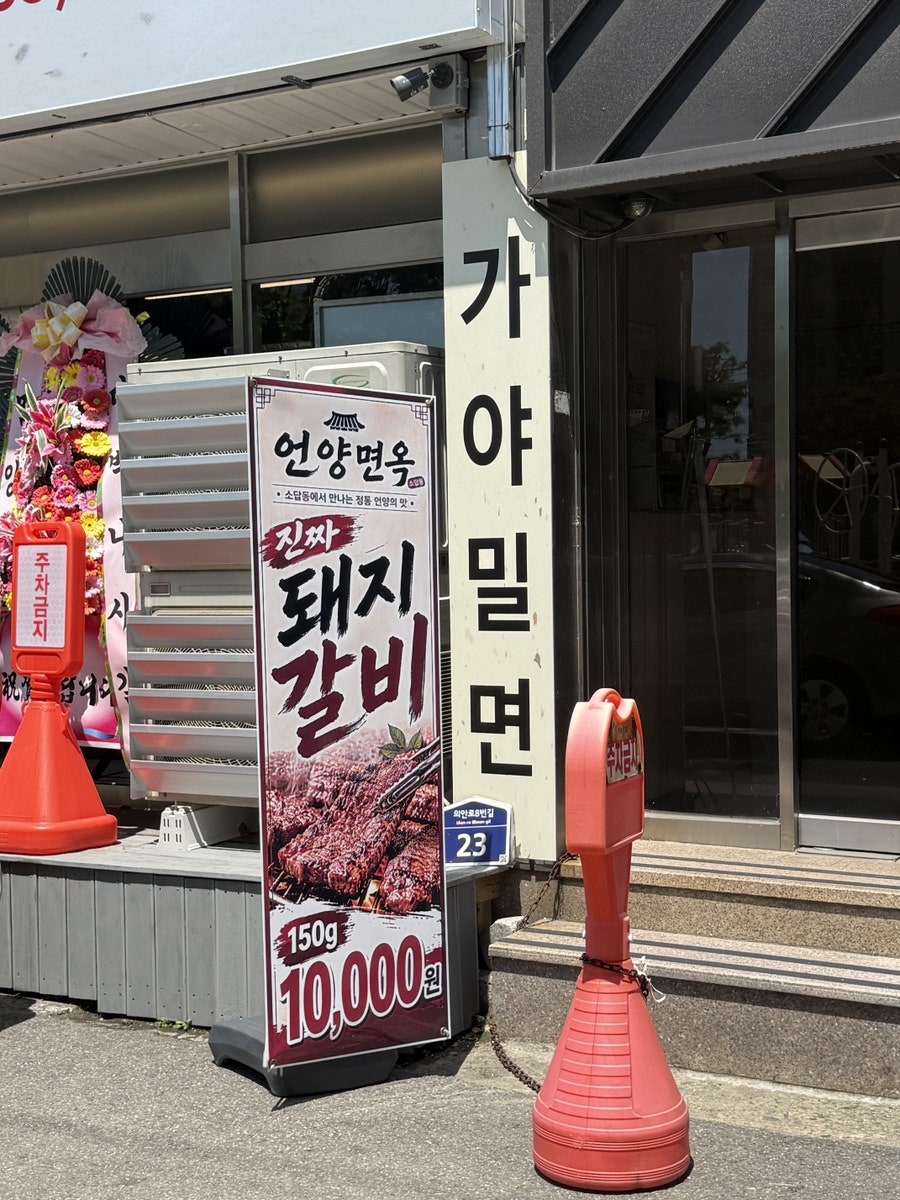 '진짜 돼지갈비 150g 10,000원' 배너와 '가야밀면' 세로 간판이 나란히 붙은 매장 옆면.
