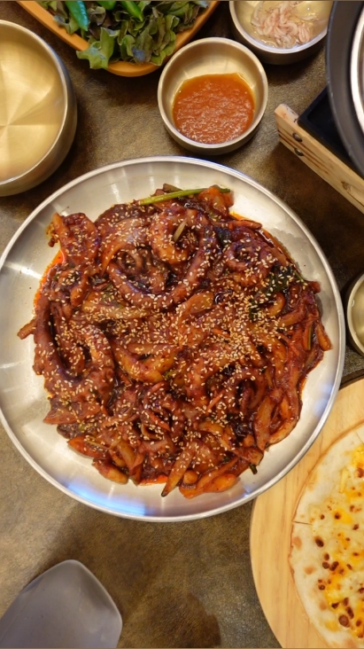 깨를 듬뿍 올린 낙지볶음 — 다리 한 점이 통통하고 양념이 잘 배어 있다