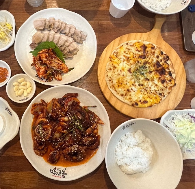 보쌈과 보쌈김치, 낙지볶음, 고르곤졸라피자가 나란히 놓인 불끈낙지스페셜 구성