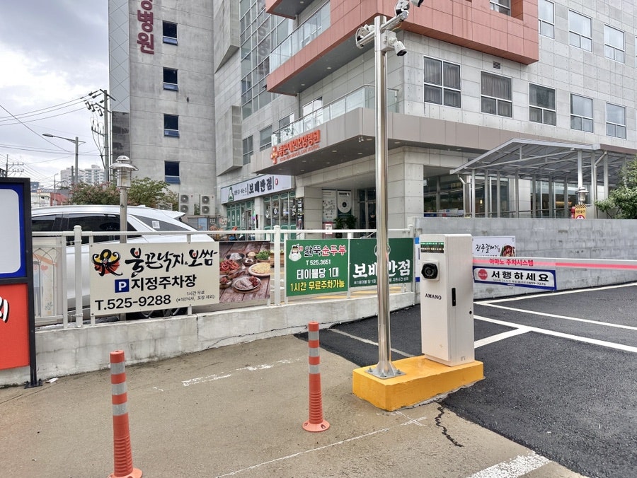매장 옆 지정주차장 입구. 테이블당 1시간 무료 주차 가능 안내가 붙어 있다