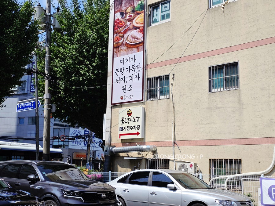"여기가 불향 가득한 낙지, 피자 원조" 건물 측면 현수막과 지정주차장 안내