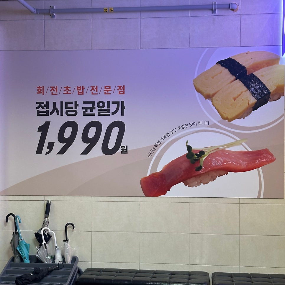 대기석 뒤편 벽면을 채운 초밥 이미지. 옆에는 우산 정리함이 놓여 있다.