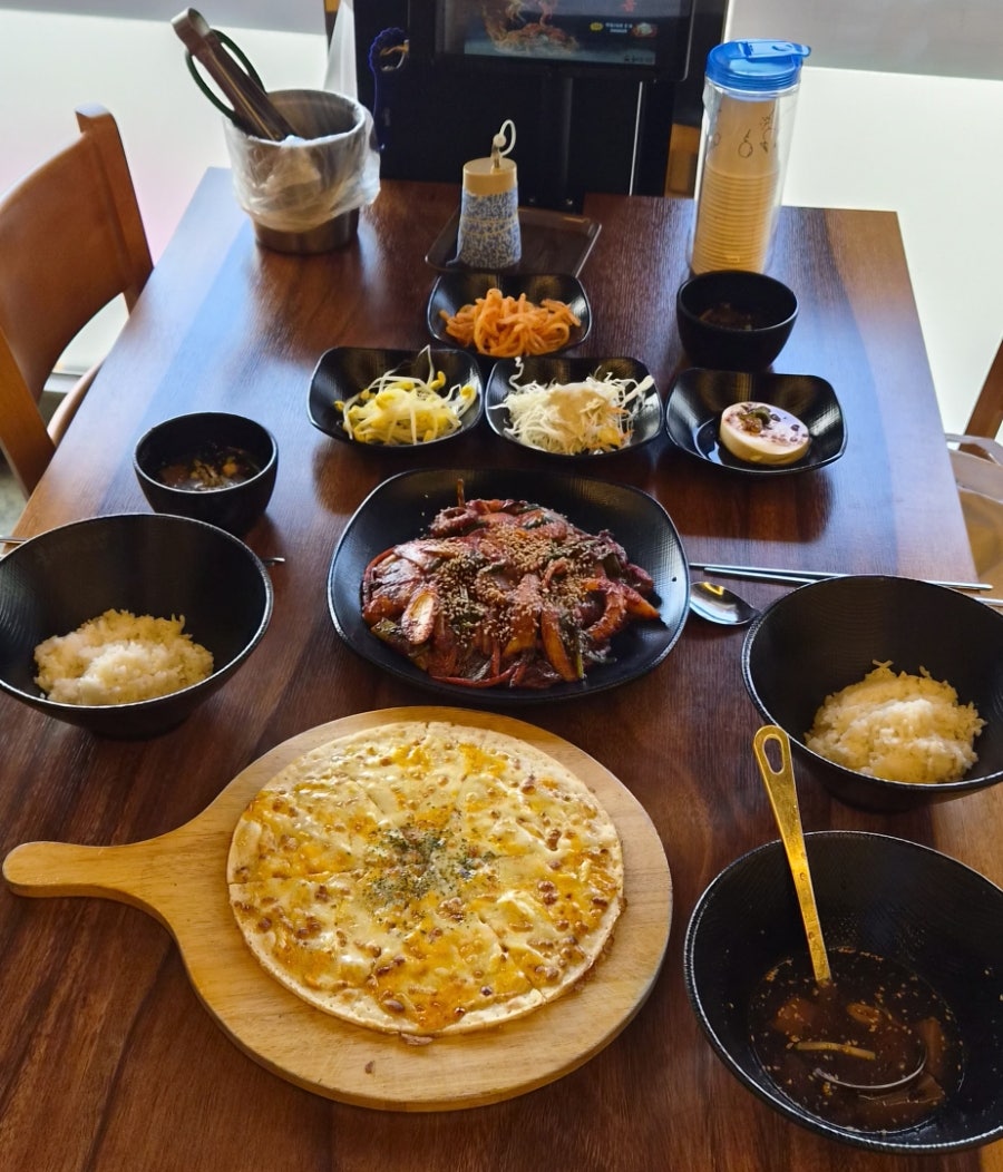 낙지볶음, 고르곤졸라 피자, 묵사발, 대접 밥과 셀프바 반찬으로 채워진 한 상