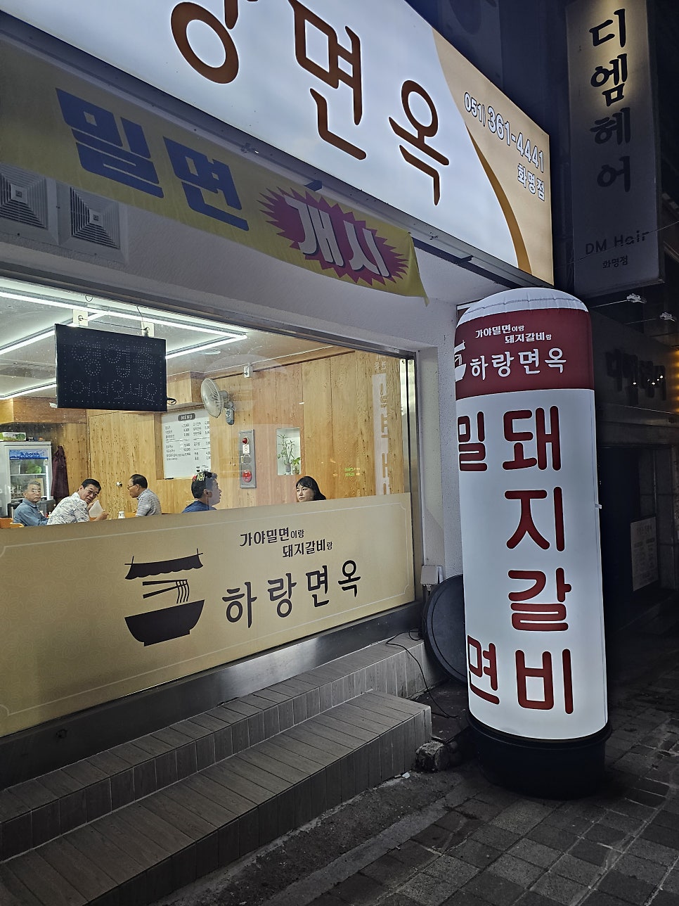 저녁 시간 창 너머로 보이는 매장 내부와 식사 중인 손님들