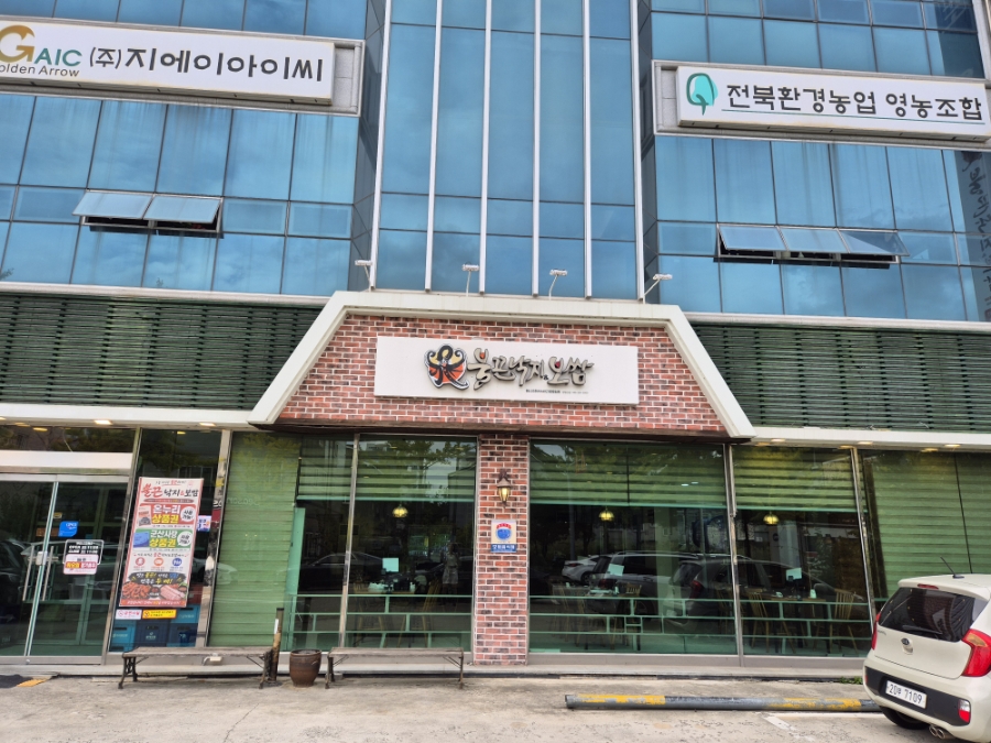 입구 옆에 걸린 낙지비빔밥 안내와 군산사랑상품권 사용 안내가 보이는 매장 외관