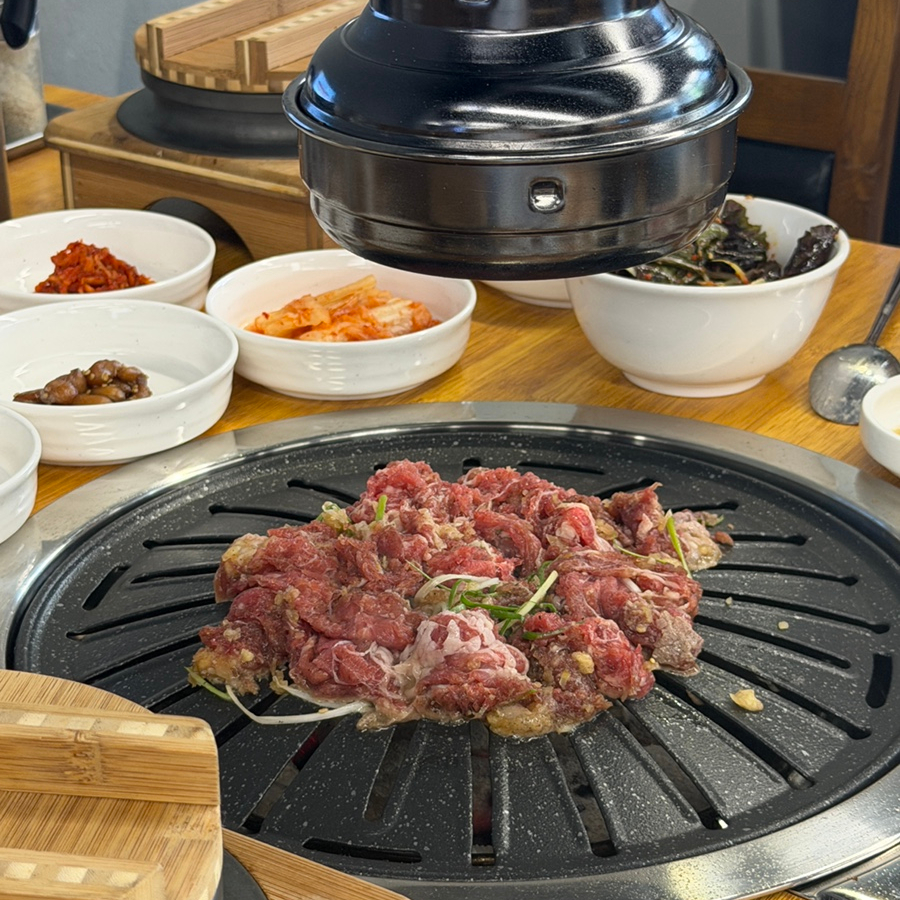 양념에 재운 얇은 소고기가 불판에 올라가기 직전, 주변으로 깔린 김치·장아찌·젓갈 반찬