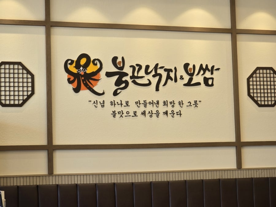 매장 벽면의 불끈낙지&보쌈 로고와 전통 창살 인테리어