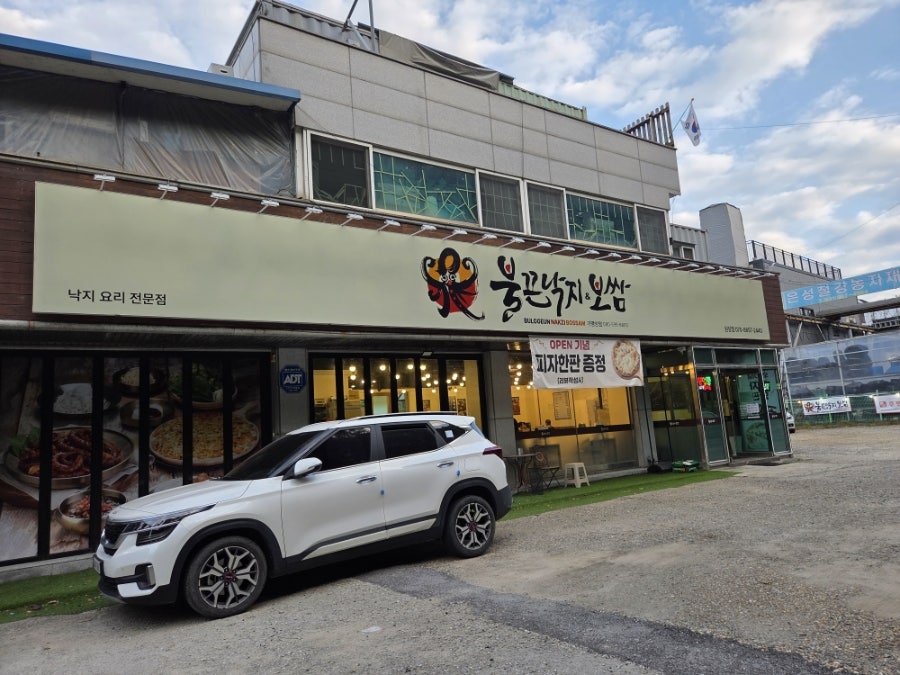'낙지 요리 전문점' 간판이 달린 매장 외관과 바로 앞 주차 공간.
