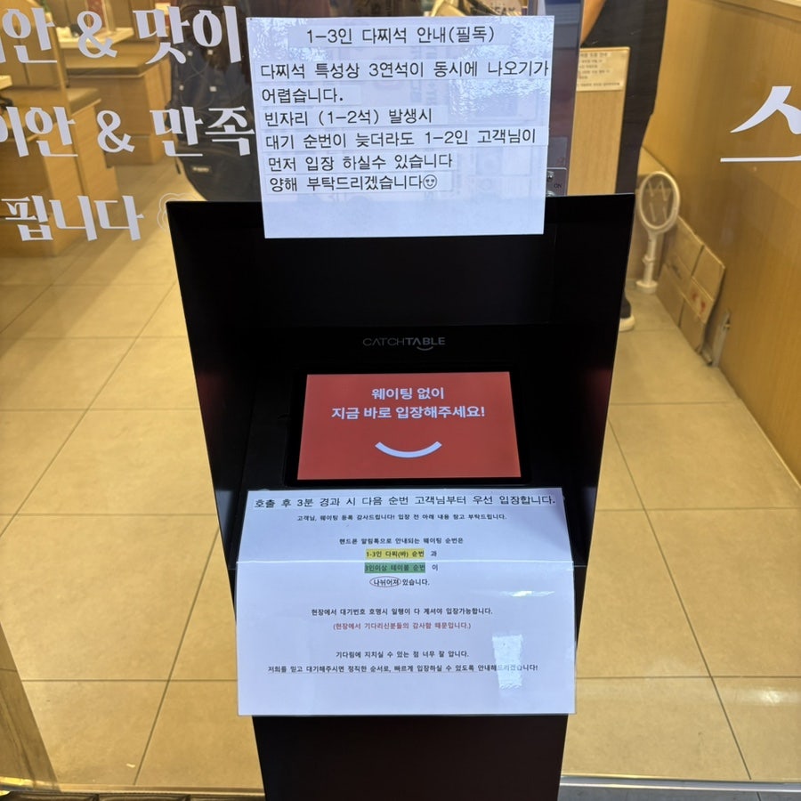 입구의 캐치테이블 단말기와 1~3인 다찌석 대기 안내문.
