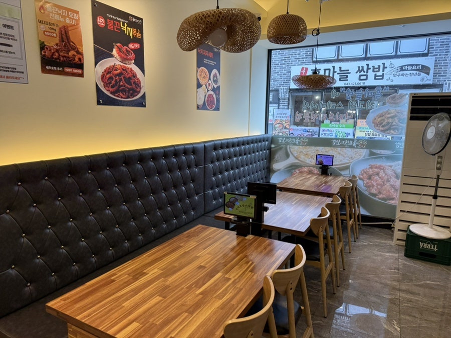 안쪽 좌석과 벽면 메뉴 포스터. 불끈낙지볶음, 낙지 토핑 안내가 붙어 있습니다.
