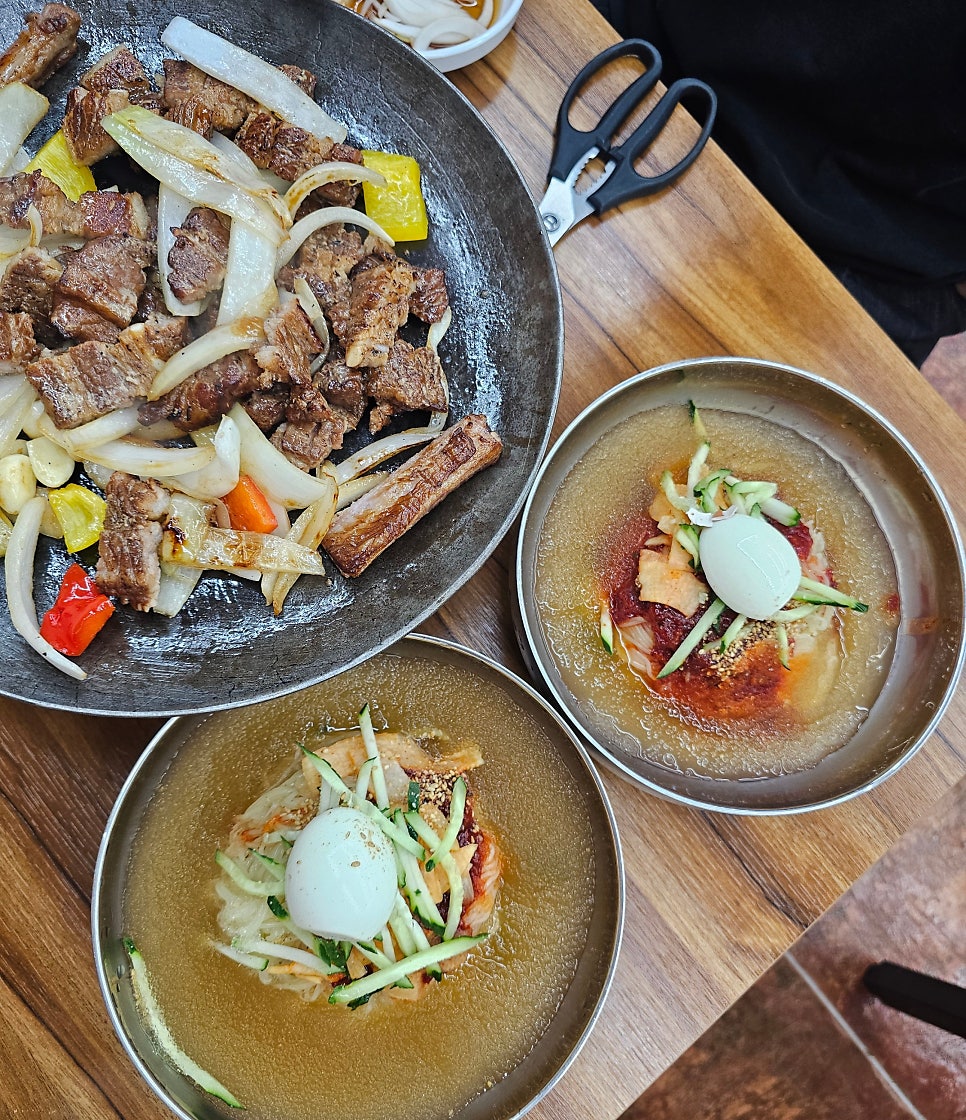 철판 양념돼지갈비와 밀면 두 그릇, 밀면에 고기를 얹어 먹는 조합