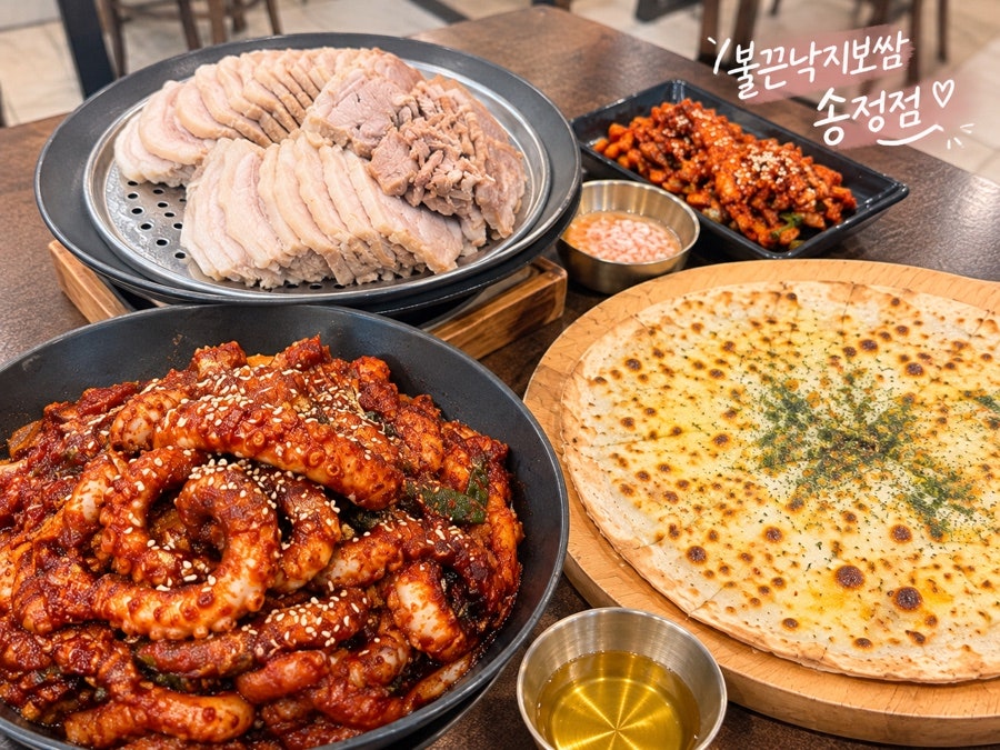 보쌈, 낙지볶음, 치즈피자가 한 상에 차려진 모습. 꿀과 새우젓도 함께 나옵니다.